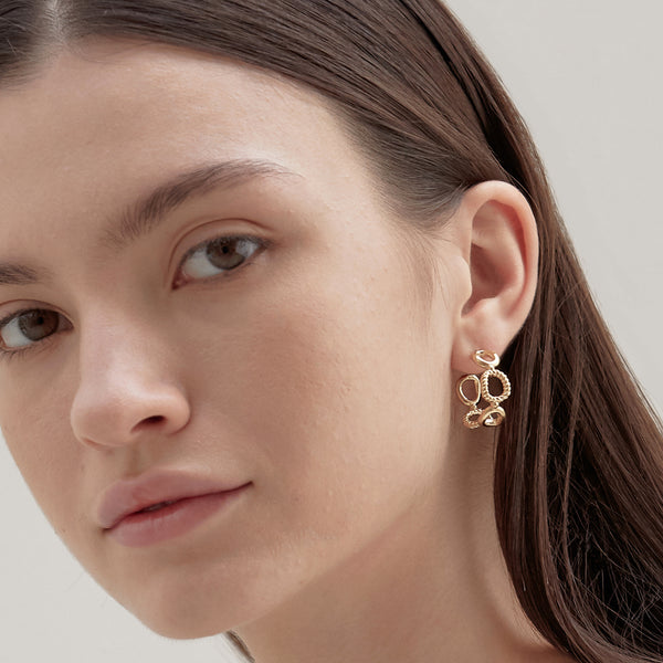 Model wearing Moyoura Connected Ovals Hoop Earrings in Gold