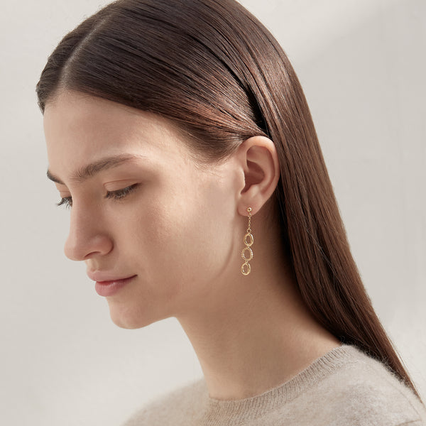 Model wearing Moyoura Connected Ovals Drop Gold Earrings side profile view