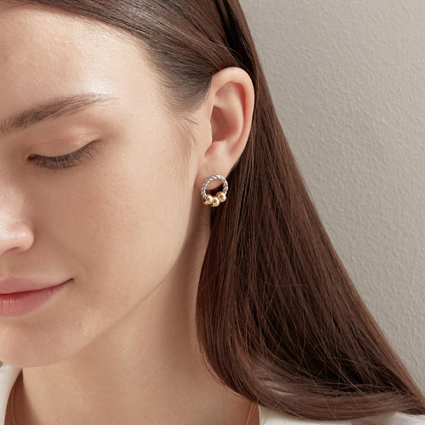 Model wearing Moyoura sterling silver hoop stud earrings with gold beads