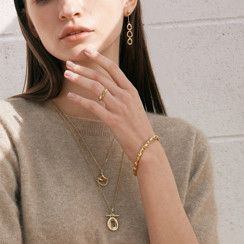 Model wearing Moyoura Natural Wave Gold Bracelet and gold jewelry