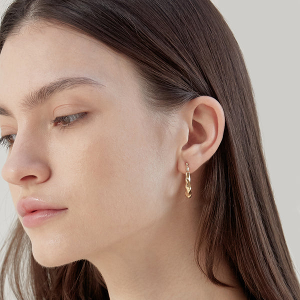 Model wearing Moyoura Natural Wave Gold Hoop Earrings