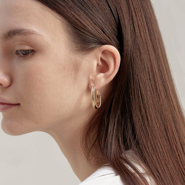 Model wearing Moyoura Spiral Edge Gold Hoop Earrings